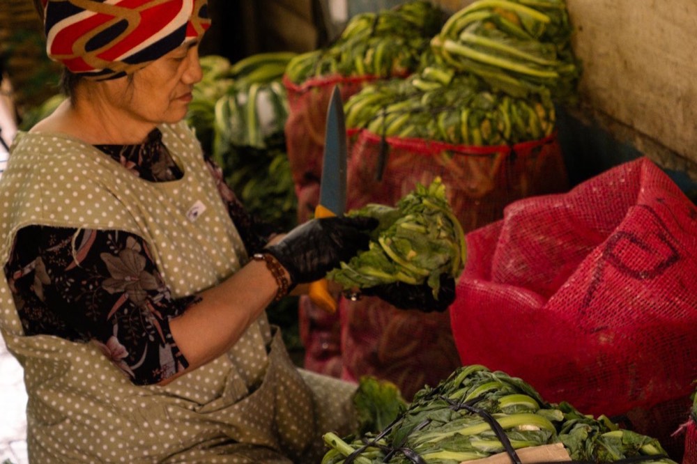 Isang vendor na nagsasaayos ng gulay sa palengke ng Baguio
